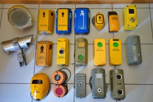 <h2>Verschiedene Anforderungstaster und Zubeh&ouml;r</h2>
                        Hier sind einige Varianten von Anforderungstastern aus meiner Sammlung zu sehen. Bei der 'Kamera' handelt es sich um einen PIR-Detektor zur Erkennung von Verkehr über die Auswertung von Wärmestrahlung. Der Lautsprecher ist eine Blindenakustik der Firma Dambach. <br> Eine umfangreiche Fotosammlung verschiedener deutscher Ampeltaster findet sich bei den Ampelbildern.
                     