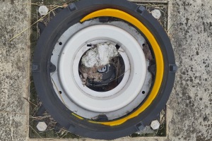 Überreste einer Leuchtsäule. In der Mitte befindet sich der elektrische Anschluss in Form einer Kaltgerätebuchse.